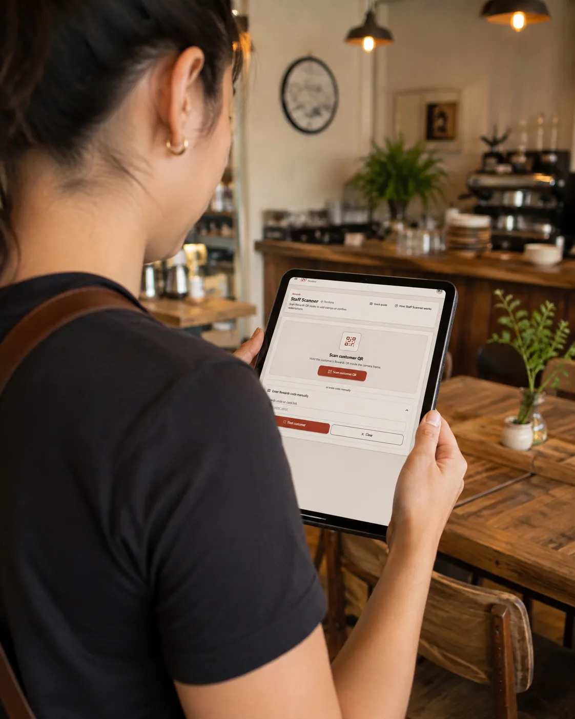 Restaurant employee using the Noshva Staff Scanner on a tablet behind the counter